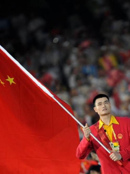 China's flag-bearer Yao Ming carries the national flag as he leads his country's Olympic team...