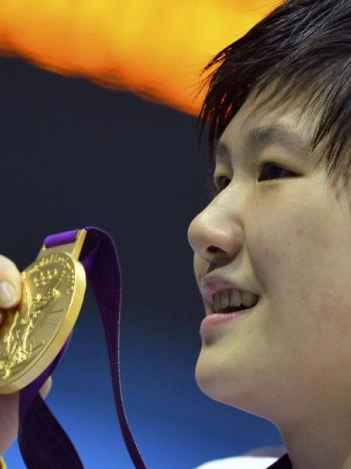 China's Ye Shiwen poses with her gold medal during the women's 200m individual medley victory...