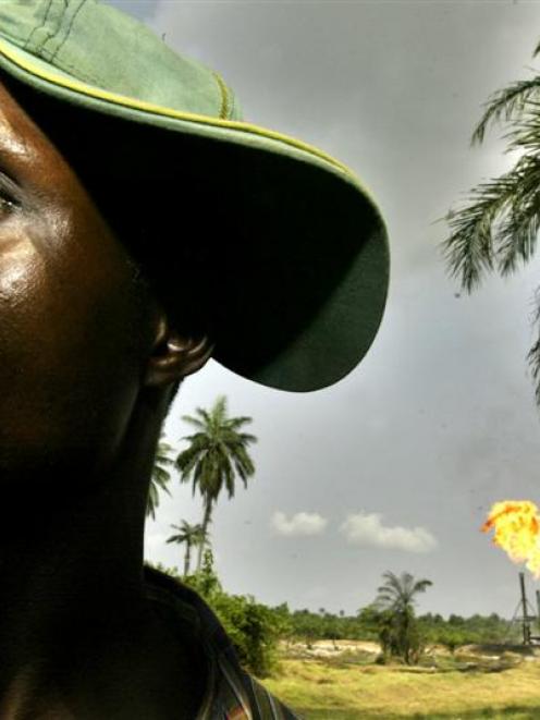 Chinedu Ugoma stands near a gas flare belonging to the Agip Oil company in Idu Ogba in Nigeria's...