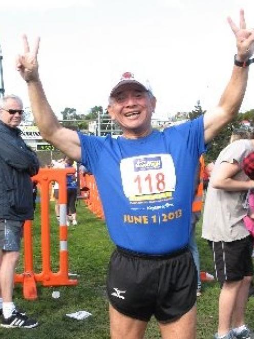 Ching-te Huang, of Taiwan, celebrates running his 106th marathon in as many weeks at the finish...