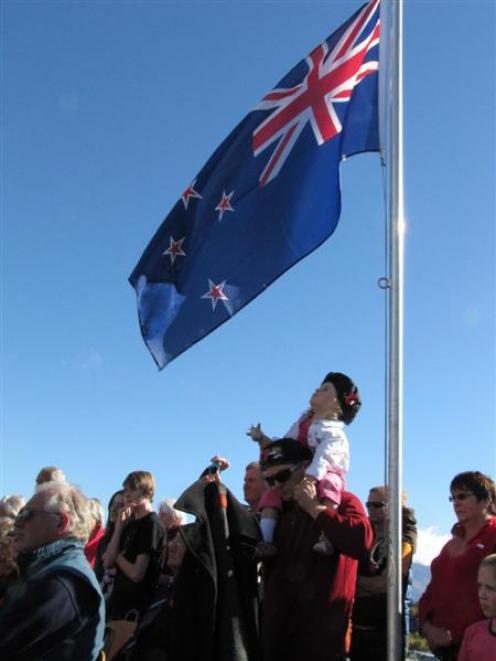 Cholula Brown (3), of Wanaka, sits on Brett Brown's shoulders and watches the New Zealand flag at...