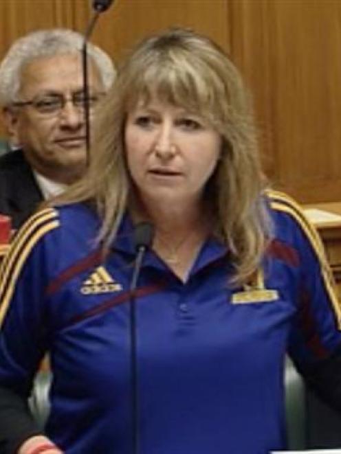 Clare Curran, wearing a Highlanders jersey, stands in Parliament yesterday. Photo by TVNZ.