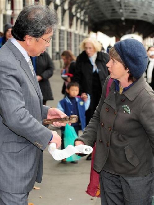 Dunedin Mayor Peter Chin receives the climate change relay baton and register of baton bearers...