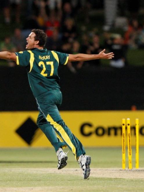 Clint McKay (C) of Australia celebrates taking the wicket of Sri Lanka's Lasith Malinga (R) to...