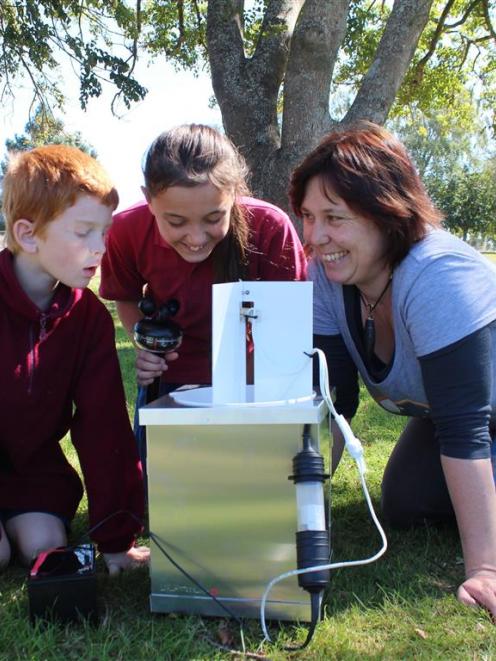 Clutha Valley School pupils Nathan Bocock (8) and Vera Stirling (12) check moth traps under the...