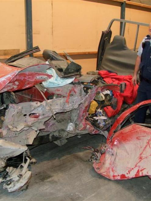 Senior Constable Robert Wallace examines the mangled remains of the twin-cab utility which...