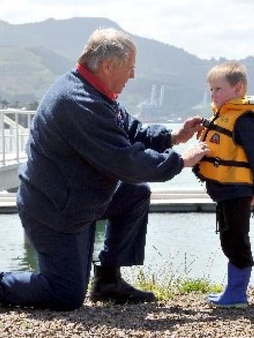 Coastguard Dunedin president Lox Kellas, of Portobello, prepares Harwood youngster Harper Wilson ...