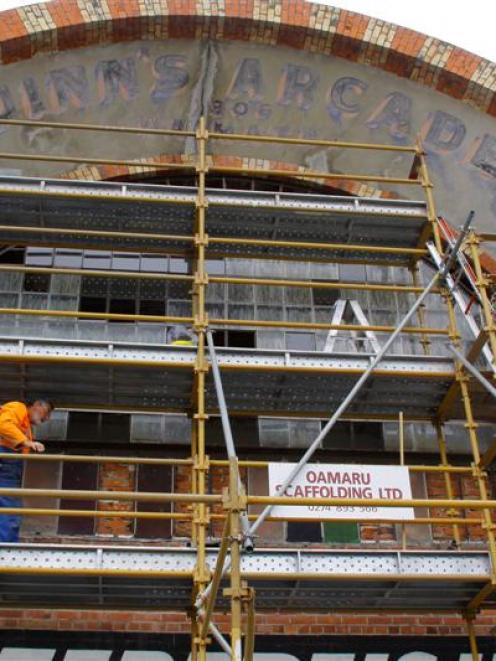 Colin Winter works on the arcade's facade. Photo by Sheryl Frew.