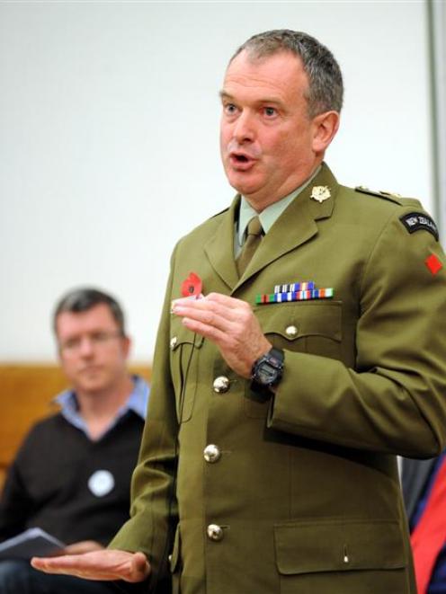 Colonel Roger McElwain debates red and white poppies with Associate Prof Richard Jackson (in...