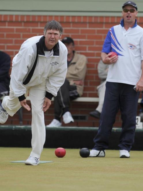 Composite team skip Nigel Birkbeck delivers a bowl as Andersons Bay skip Evan Roberts looks on...