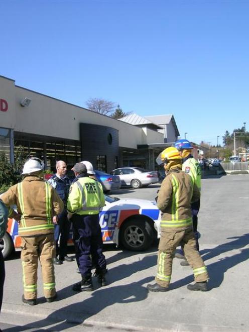 Constable Bruce McLean (facing camera) briefs fire officers outside Wanaka New World during...