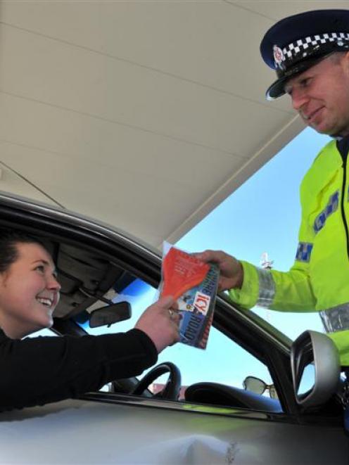 Constable Dave Bullot hands an ice scraper and free coffee to motorist Rachel Ovens at BP Connect...