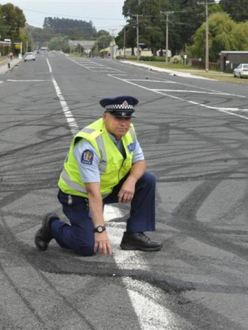 Constable Graeme Ferguson, of Balclutha, examines damage to Eddystone St, Kaitangata, after...