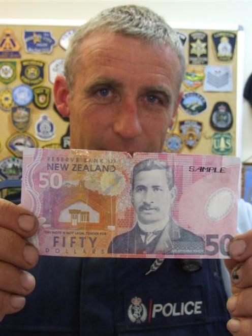 Constable Greg Nolet holds a counterfeit $50 note presented at a Wanaka shop this week. Photo by...