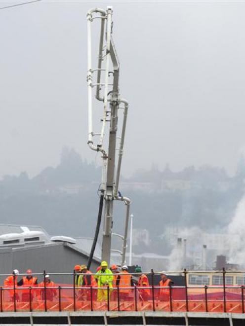 Contractors pour concrete for a new $2.2 million bridge across the Water of Leith for the...