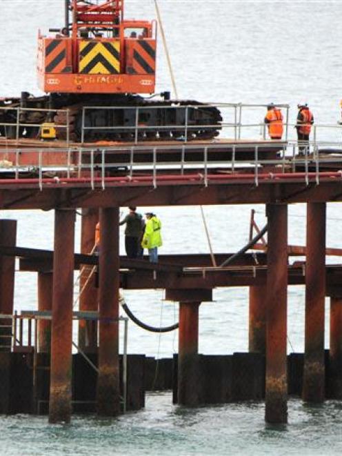 Contractors watch concrete being poured into a structure beneath the ocean as construction of the...