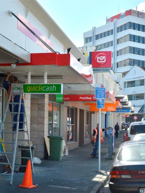 Contractors work to finish the new New Zealand PostShop in Moray Pl, in Dunedin, in time for...