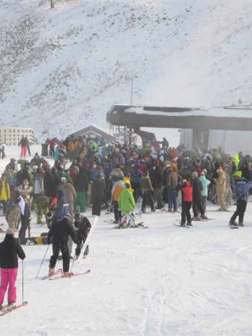 Crowds queue for the Coronet Express chairlift at Coronet Peak in near white-out conditions...