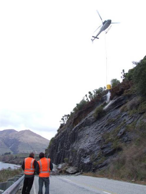 Council contractors employed a helicopter to drop water on a rockfall site at the Glendhu Bluffs...