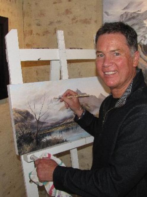 Craig Primrose, at work on his latest painting, Lake Hayes, at Artbay Gallery, in Queenstown...