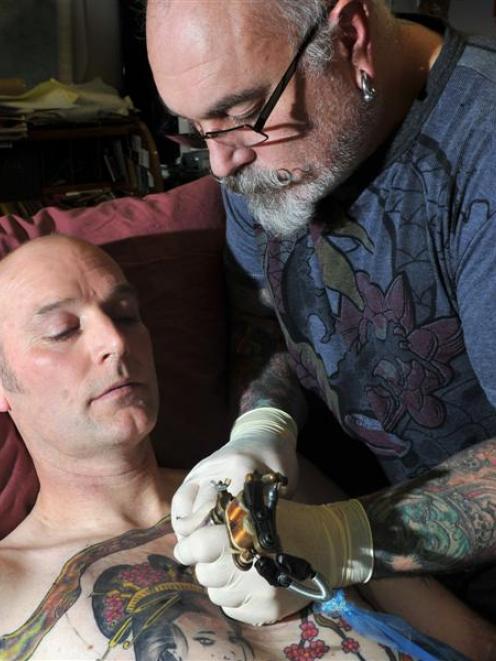 Crazy Horse Tattoo Studio owner Chris Downing tattoos Dave Dickie in Dunedin last week.  Photo by...