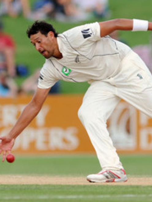 New Zealand's Daryl Tuffey fields off his own bowling against Pakistan on the third day of the...