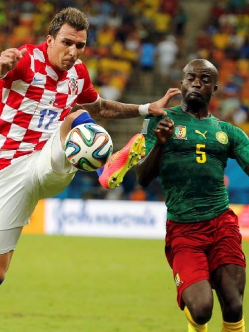 Croatia's Mario Mandzukic (L) fights for the ball with Cameroon's Dany Nounkeu. REUTERS/Siphiwe...