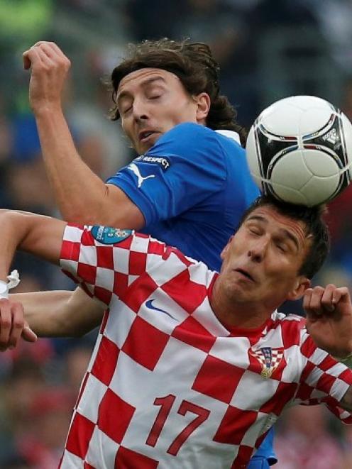 Croatia's Mario Mandzukic (R) vies for the ball with Italy's Riccardo Montolivo during their...