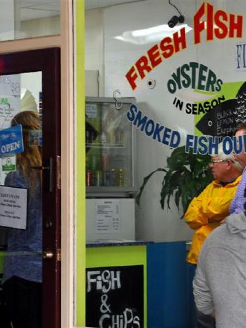 Cruise ship passengers queue at Best Cafe, in Lower Stuart St, for fish and chips yesterday....