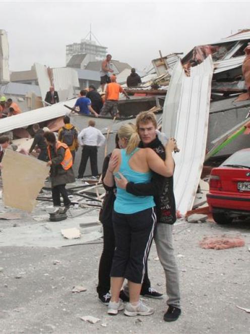 CTV staff comfort each other as rescue personnel work to rescue people trapped in the collapsed...