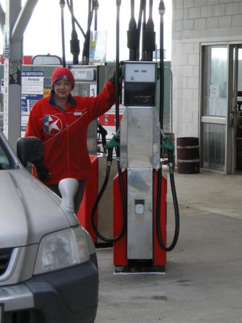 Curson Motors employee Fiona Laurence fills up a car on Tuesday morning when the service station...