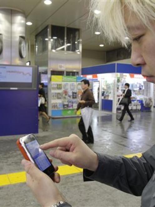 Daisuke Tsuda tweets with his mobile phone at a station in Tokyo. "Japan is enjoying the richest...