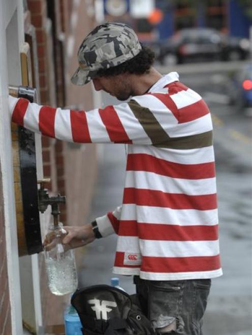 Dan Roberts fills his bottles  from the Speight's Brewery water tap yesterday. Photo by Linda...