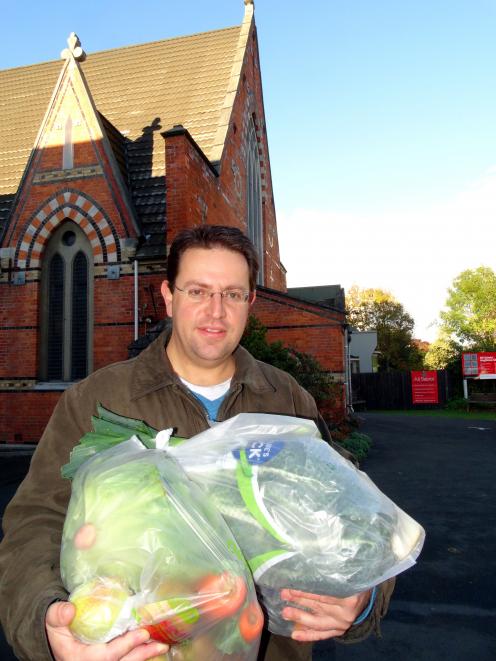 Daniel Fridberg picks up his family vegetable pack from All Saints Church where the new Vege Co...