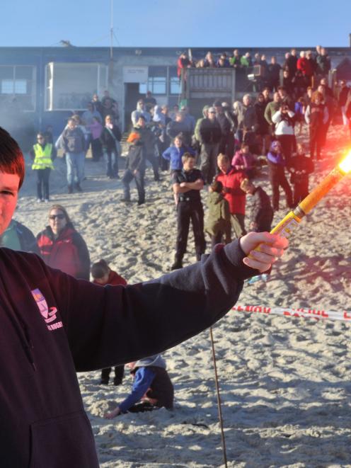 Danyon Noakes (13), of Dunedin, holds a burning flare at St Kilda Beach yesterday. Photo by...