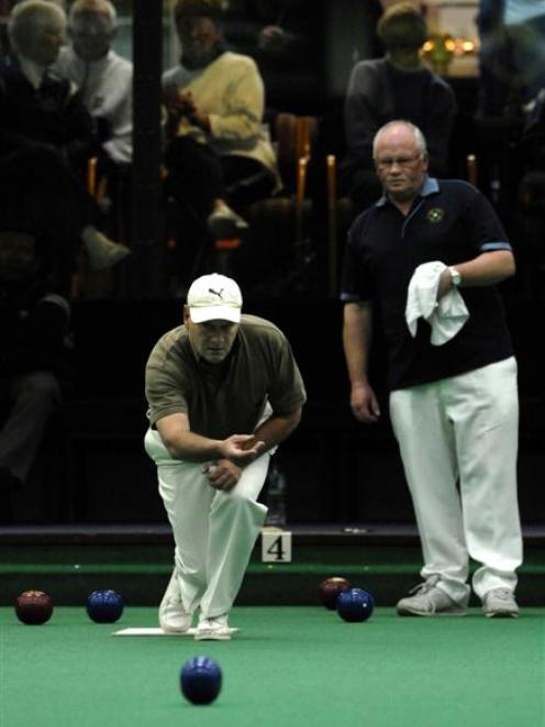 Dave Archer (Taieri) delivers a bowl as his opponent, Dennis Leeden (Wakari), looks on during the...