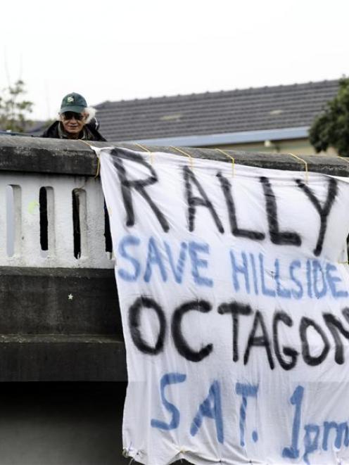 Dave Kearns and Mike Tahana hang a Hillside protest banner from the Roslyn overbridge yesterday....