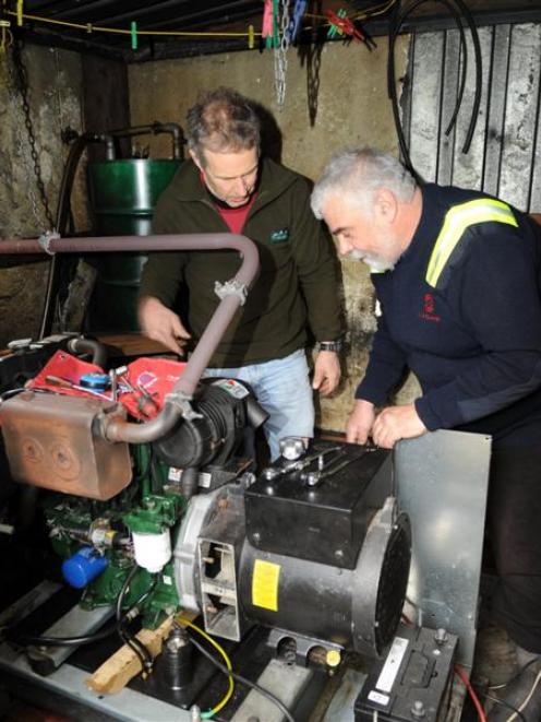 Dave Rosanowski (right) and Alistair Wilson work on a generator on Codfish Island.