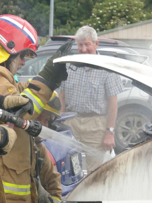 David Thorpe looks on as Balclutha Fire Brigade members put out a suspected electrical fire in...