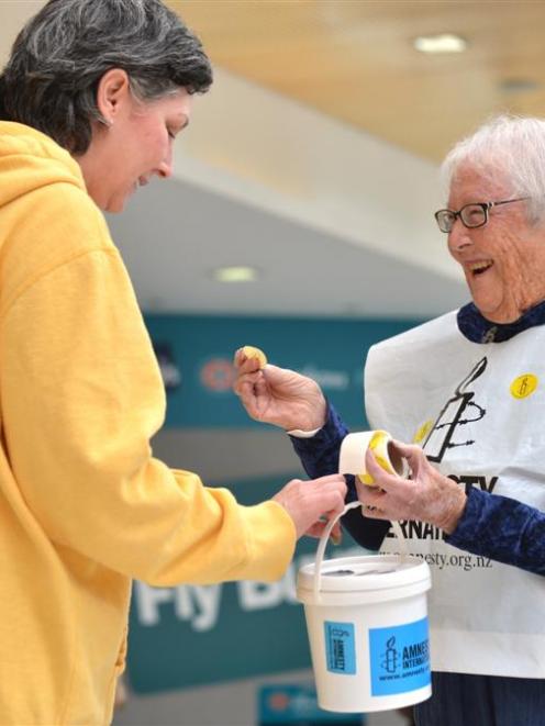 Dawn Ibbotson (right) hands out a sticker to Tenoch King while collecting for Amnesty...