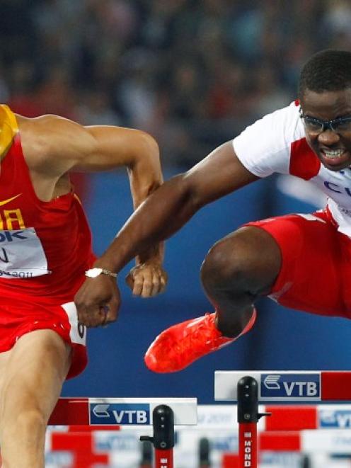 Dayron Robles of Cuba (R) makes contact with Liu Xiang of China as they go over the final hurdle...