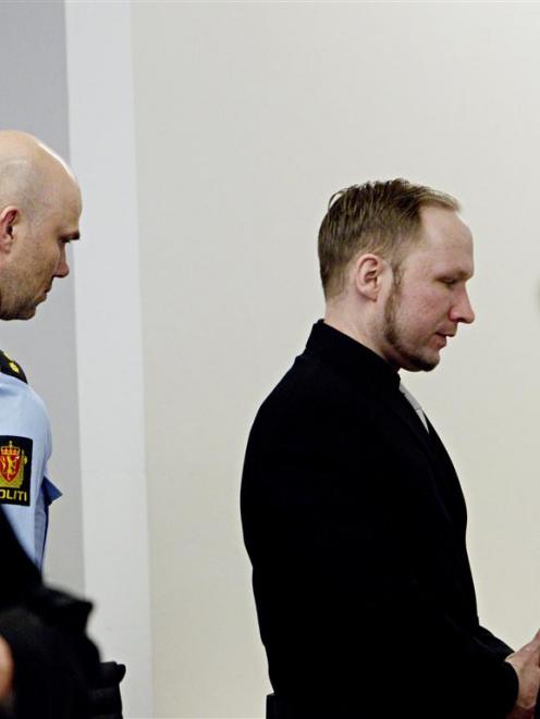 Defendant Anders Behring Breivik (C) leaves the courtroom at the end of the fifth day of his...