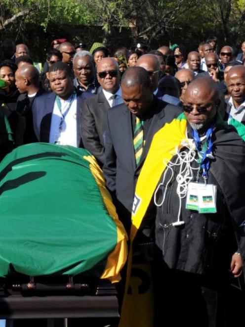 Delegates from the African National Congress transport the coffin of Nelson Mandela at his home...