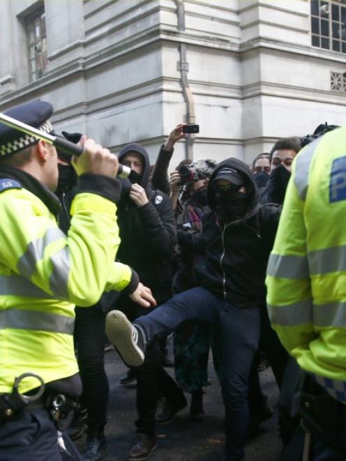 Demonstrators are confronted by police officers as they participate in a protest against student...