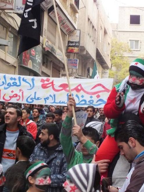 Demonstrators hold a banner during a protest against Syria's President Bashar al-Assad after...