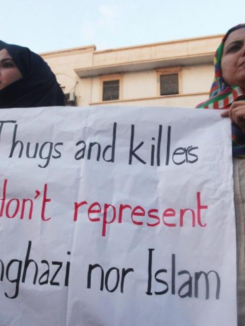 Demonstrators hold a placard during a rally in Benghazi to condemn the killers of the US...