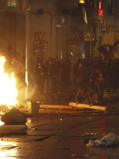 Demonstrators set barricades on fire as they clash with riot police during a protest against...