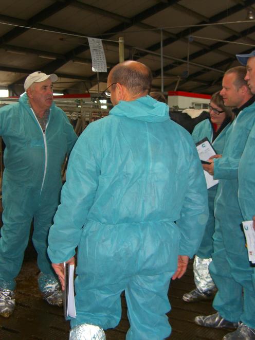 Denis Aitken (wearing the white cap), of Maungatua,  discusses Holstein Friesian characteristics...