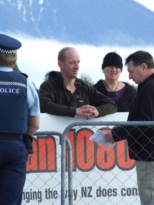 Department of Conservation principal compliance officer Alan Christie (right) issues professional...