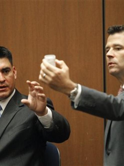 Deputy District Attorney. David Walgren, holding a bottle of propofol, questions Alberto Alvarez,...